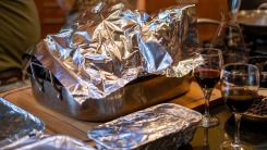 A turkey tented in foil on a kitchen counter.