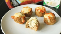 Cheese stuffed meatballs on a white plate.