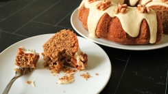 A slice of walnut bundt cake half eaten on a plate.