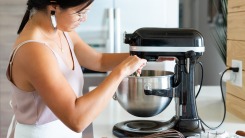 A woman mixing ingredients in a stand mixer.
