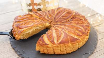 A round puff pastry dessert with fairy lights in the background.