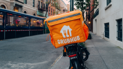 grubhub delivery bag on the back of a bike parked on a city sidewalk